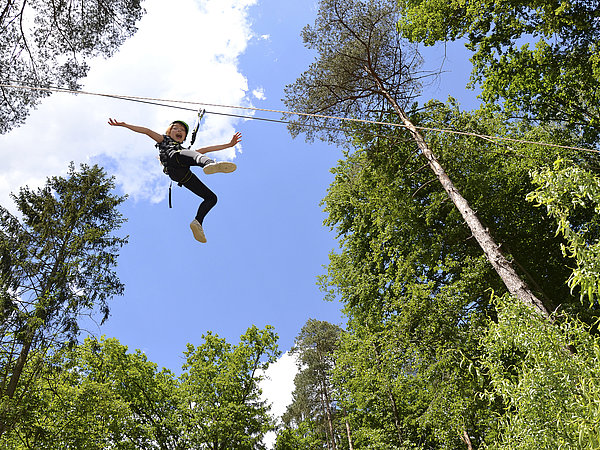 Show mit dem lebendigen Spinosaurus! Danach Freizeit mit Spaß auf der Riesen-Dinorutsche, am Pool, Flying Fox, Beachvolleyball uvm. Das Foto zeigt einen unserer Schüler am Flying Fox hoch über den Wäldern und Sauriern des Styrassic Parks in Bad Gleichenberg